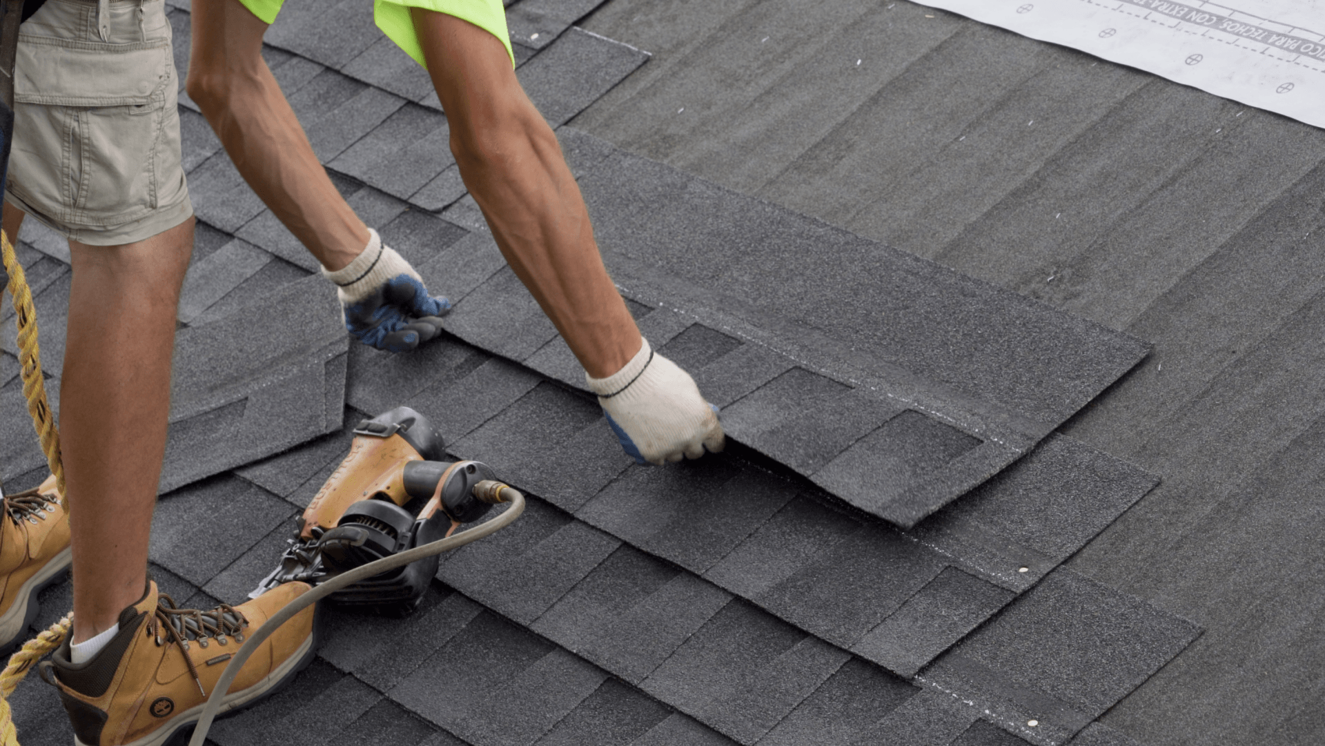 A man is installing shingles on a roof.