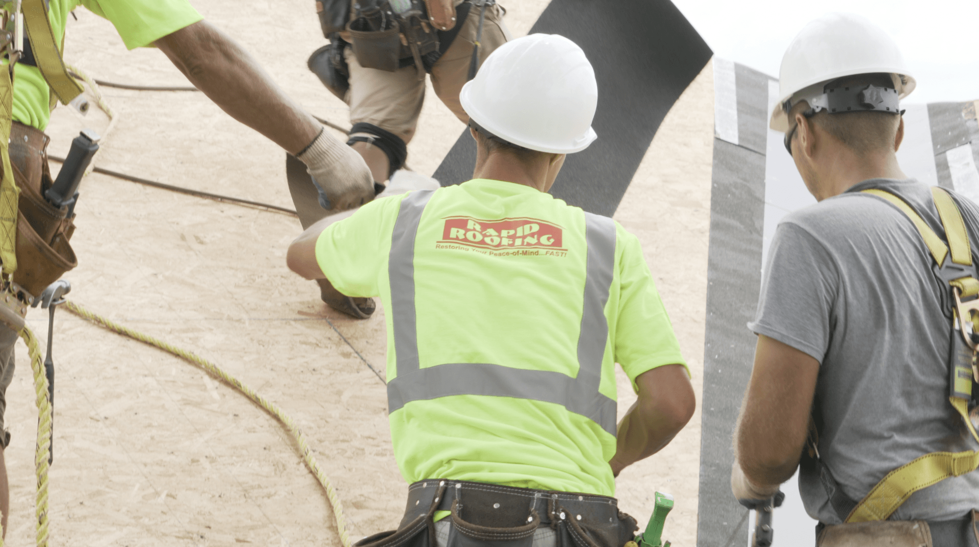 A group of construction workers are working on a roof.