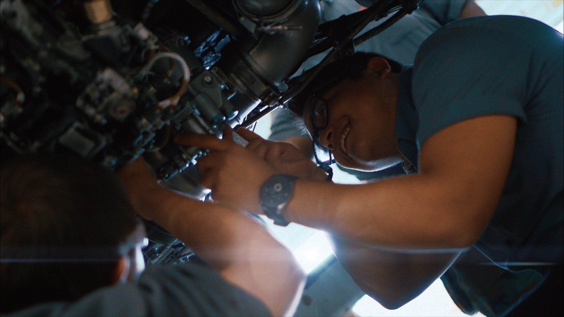 A man is working on a motorcycle engine in a garage.
