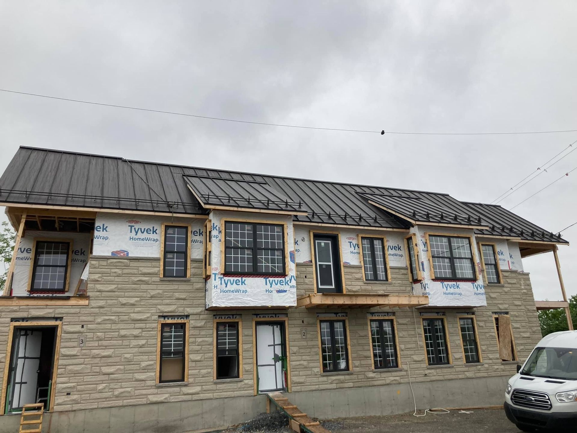 Un grand bâtiment en briques avec un toit en métal est en cours de construction.