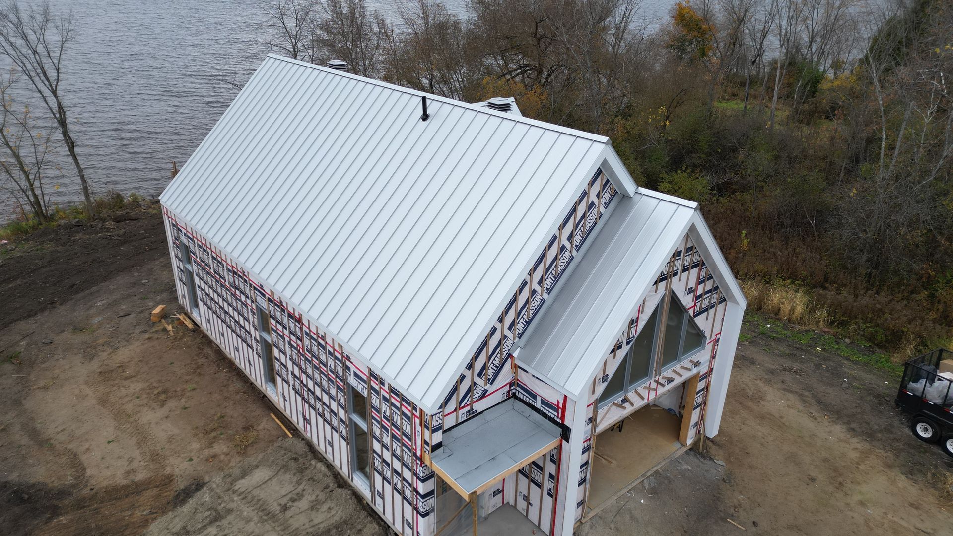 Une vue aérienne d'une maison en construction à côté d'un plan d'eau.