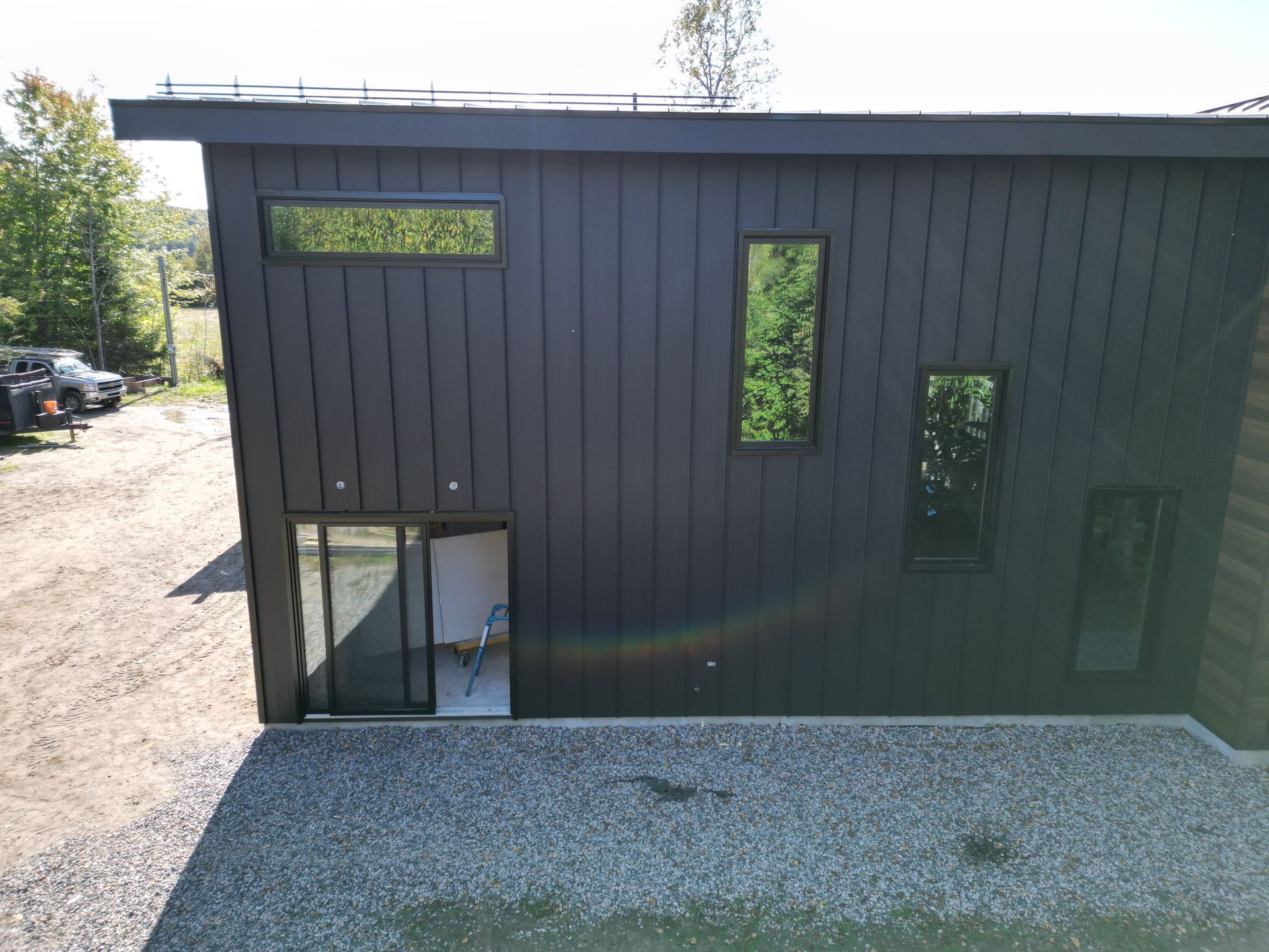 Une vue aérienne d'une maison noire avec une porte coulissante en verre.