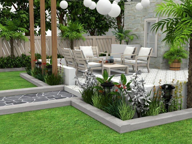 Patio with outdoor seating, walkway, and greenery, including white chairs, lawn, and plants.
