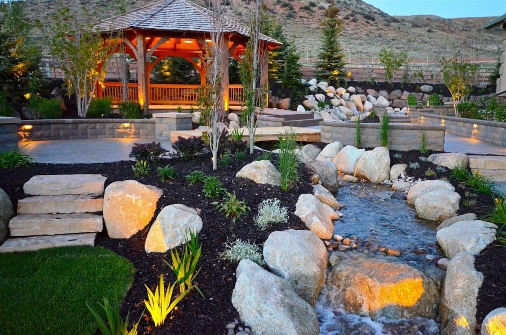 Wooden gazebo over a landscaped garden with a stream and boulders. Wooden gazebo over a landscaped garden with a stream and boulders.