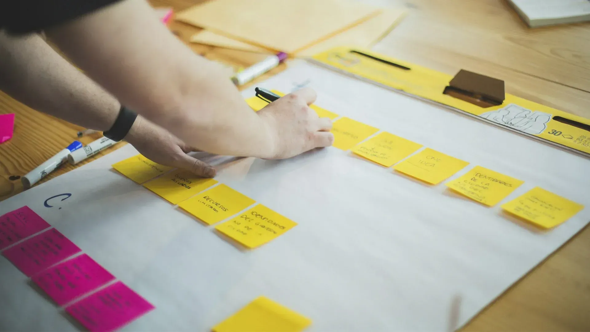 A person is putting sticky notes on a piece of paper.