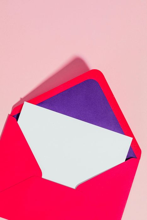 A red envelope with a white piece of paper in it.