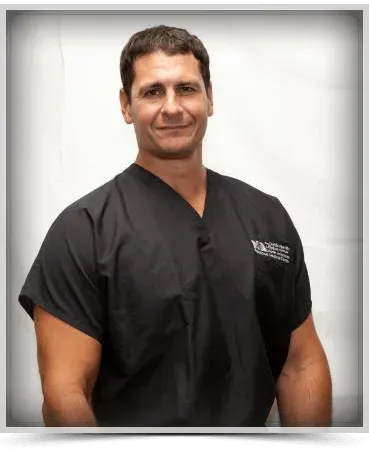A man in a black scrub is smiling for the camera