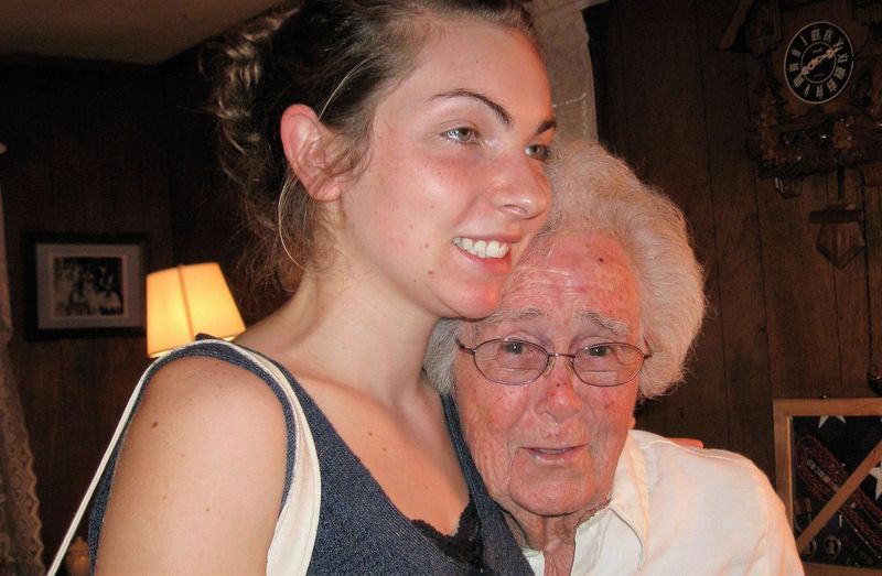 A young woman hugging an older woman with a clock in the background