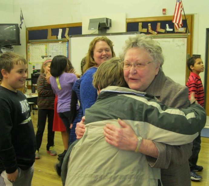 A group of people hugging in front of a sign that says hill