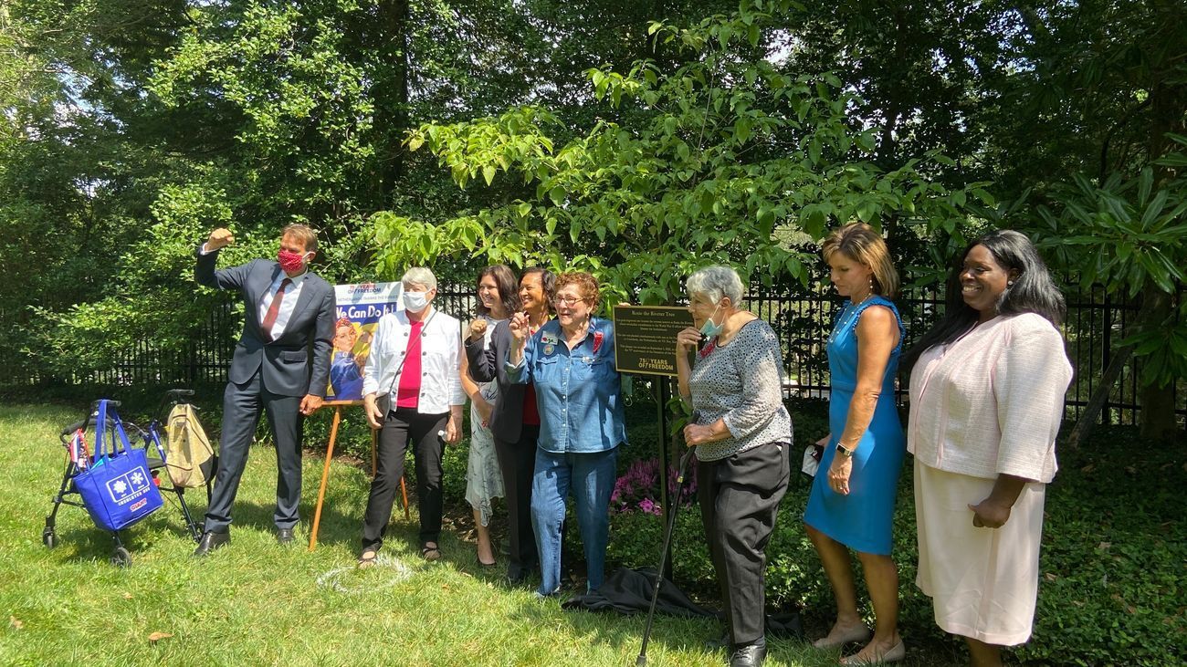 A group of people are standing in a grassy field.