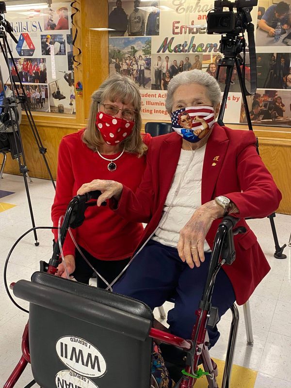 Two women wearing face masks are standing next to each other