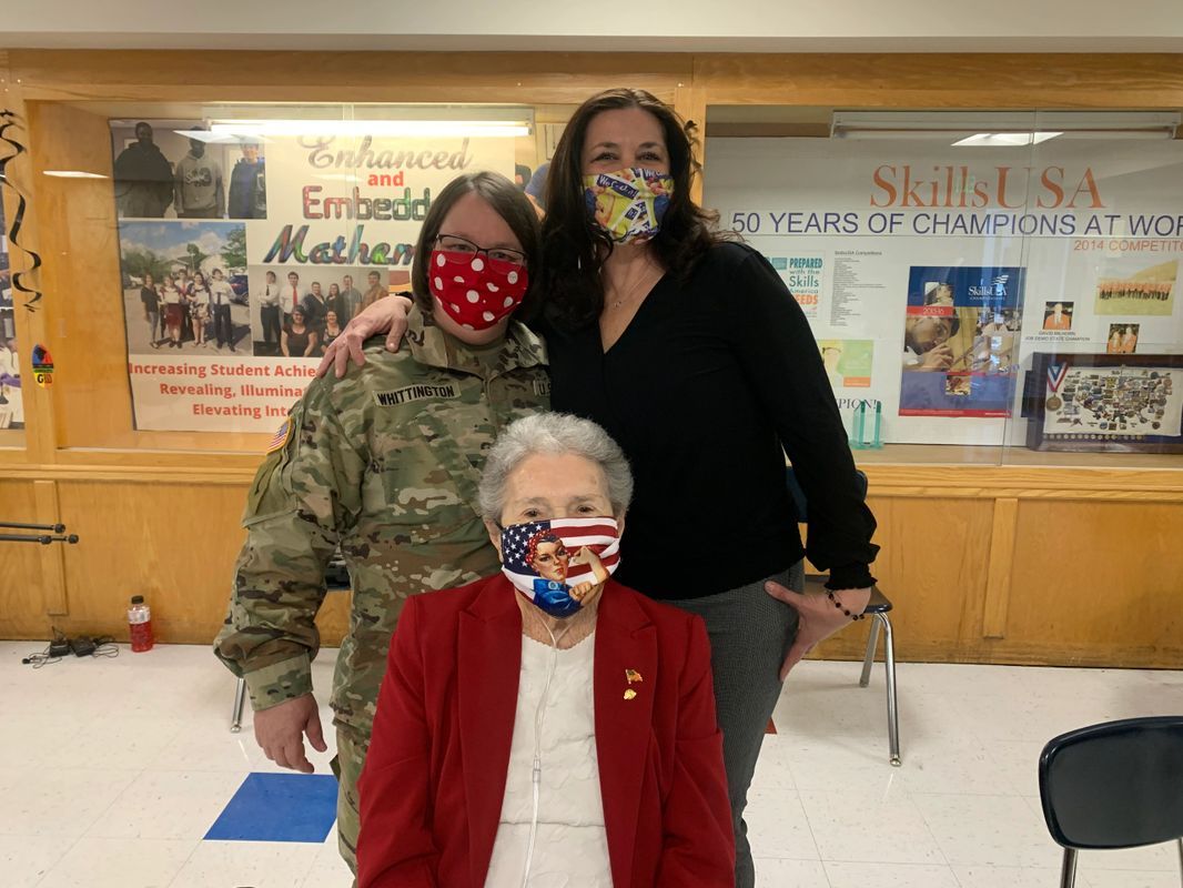 Three people wearing face masks are posing for a picture