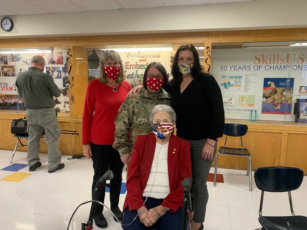 A group of people wearing face masks are posing for a picture.