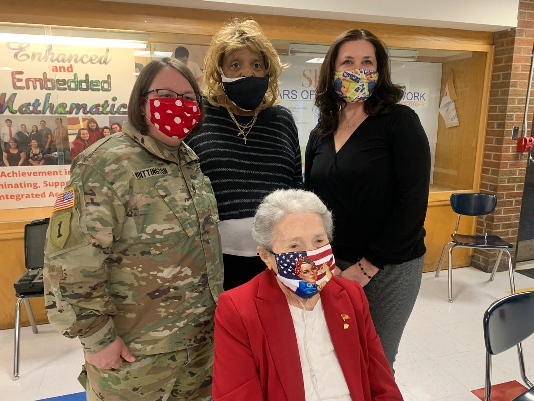 A group of women wearing face masks are posing for a picture.