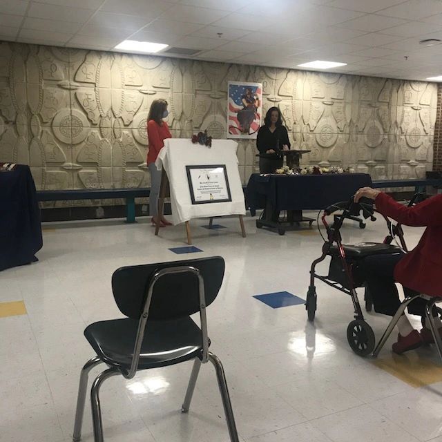 A woman sitting in a chair with a walker in a room