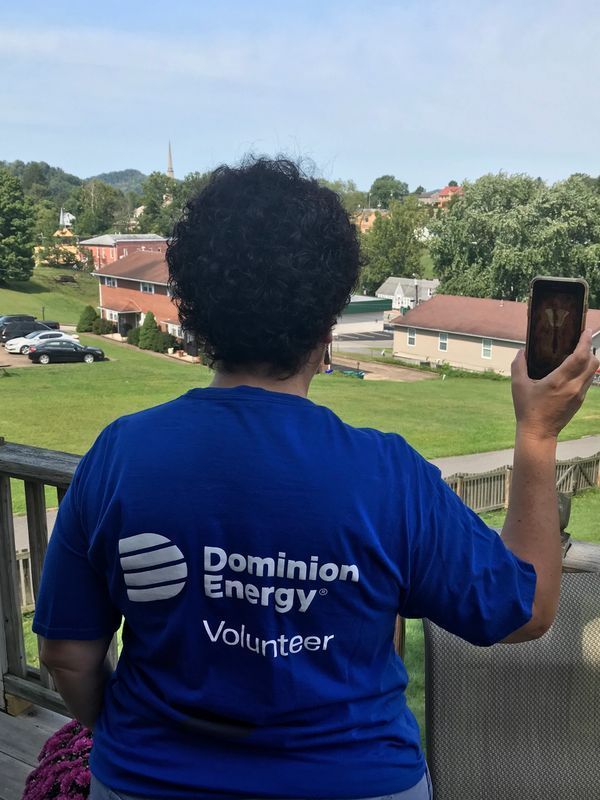 A woman wearing a blue shirt that says dominion energy volunteer