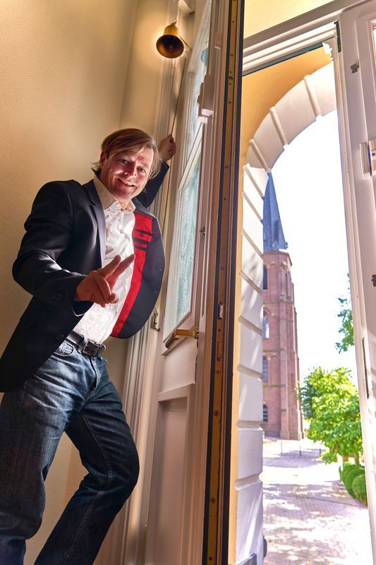A man in a suit and tie is standing in an open doorway