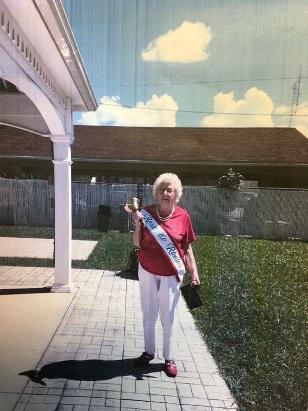 A woman wearing a sash that says ' i 'm a king ' on it