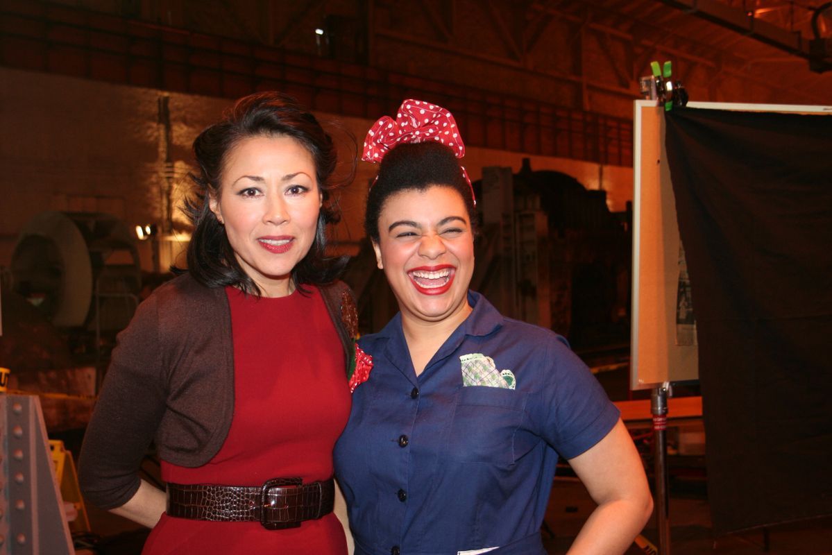 Two women posing for a picture with one wearing a red dress