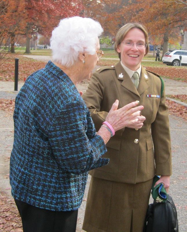 A woman in a military uniform is talking to an older woman