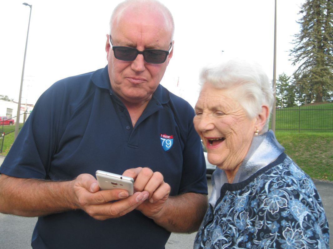 A man and a woman are looking at a cell phone