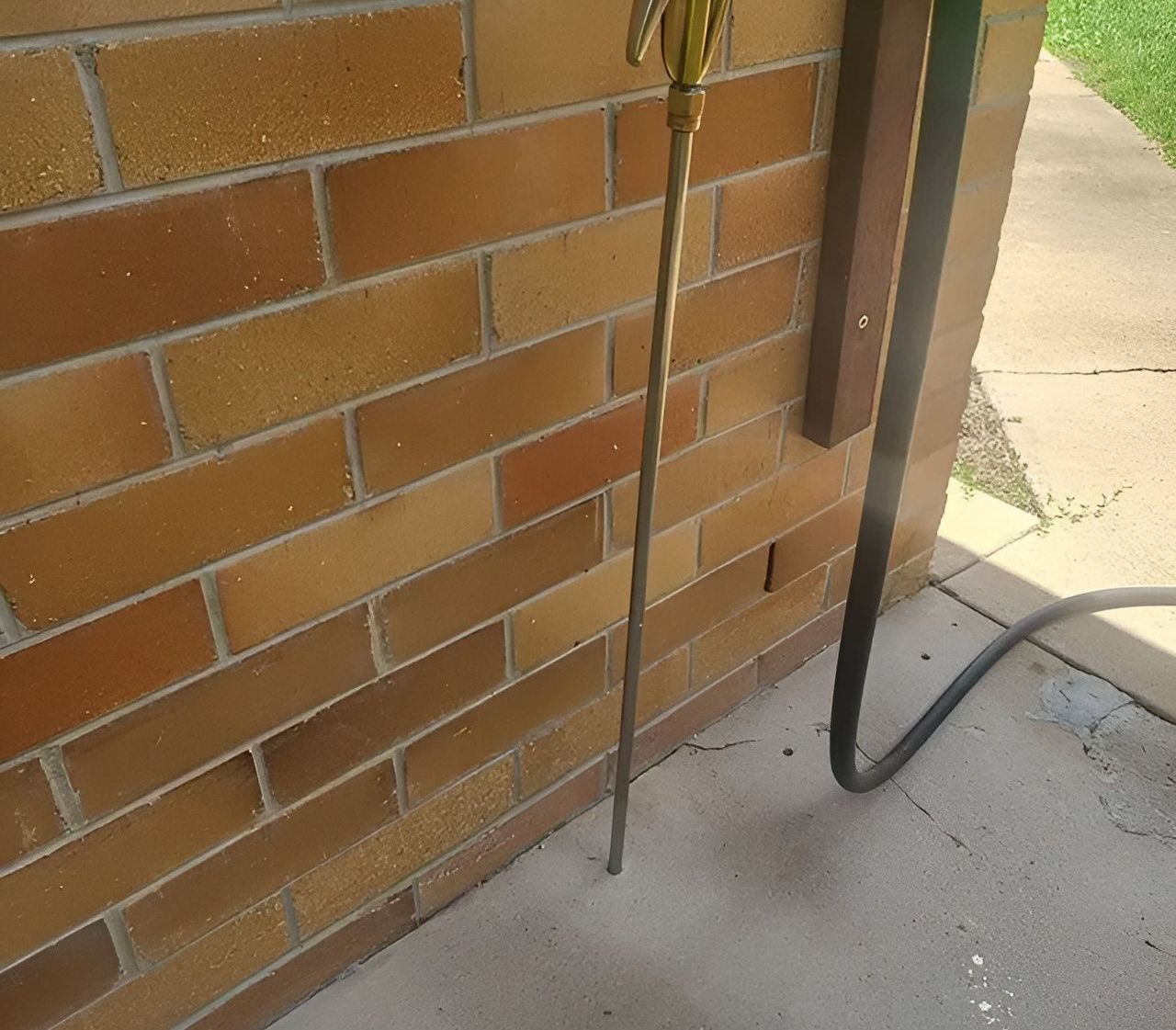 A Brick Wall With a Hose Attached to It — Superior Termite & Pest Control in Bundaberg, QLD