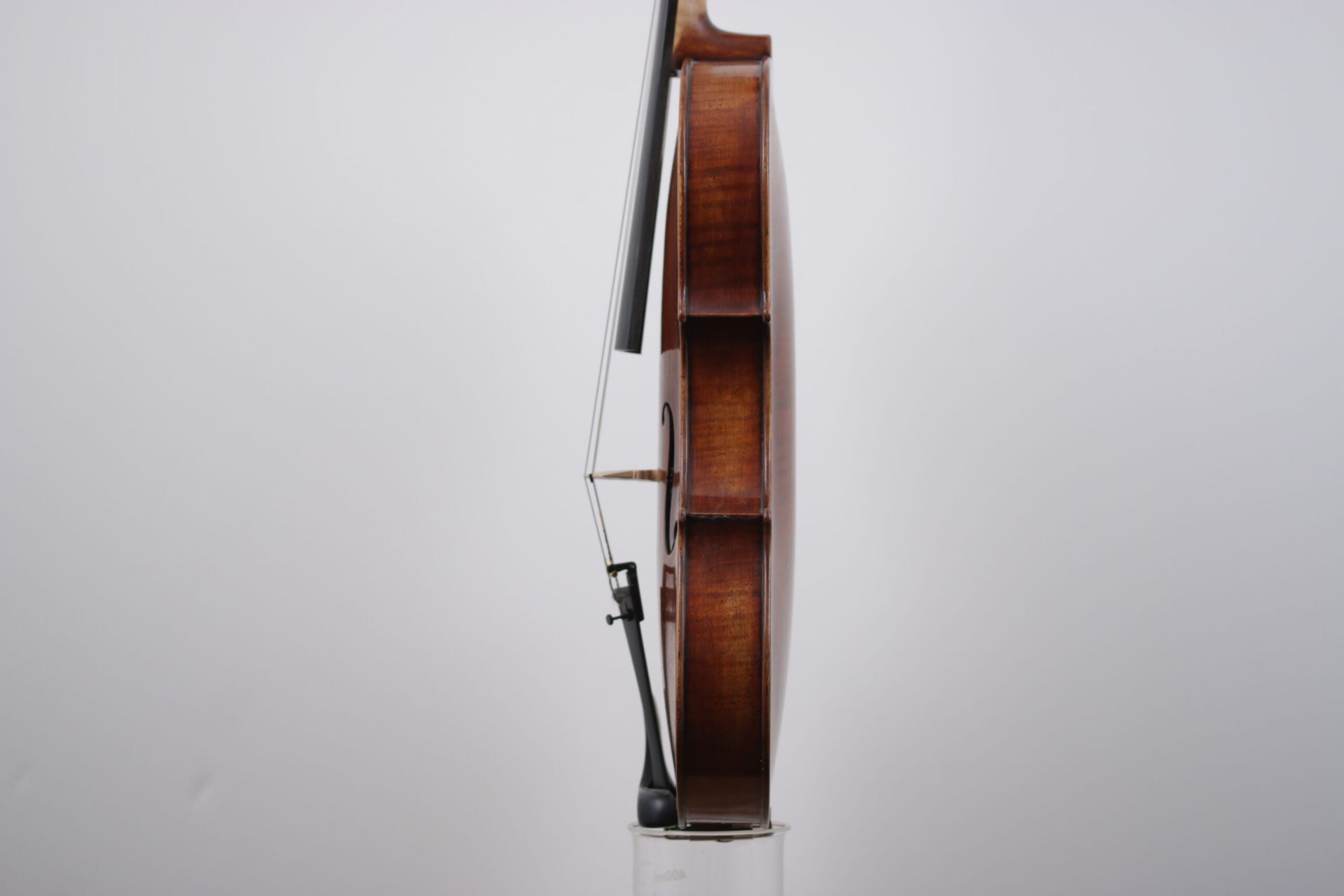 A violin is leaning against a white wall.