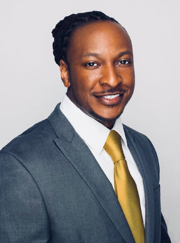A man in a suit and tie is smiling for the camera.