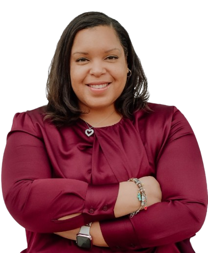 A woman in a maroon shirt is smiling with her arms crossed