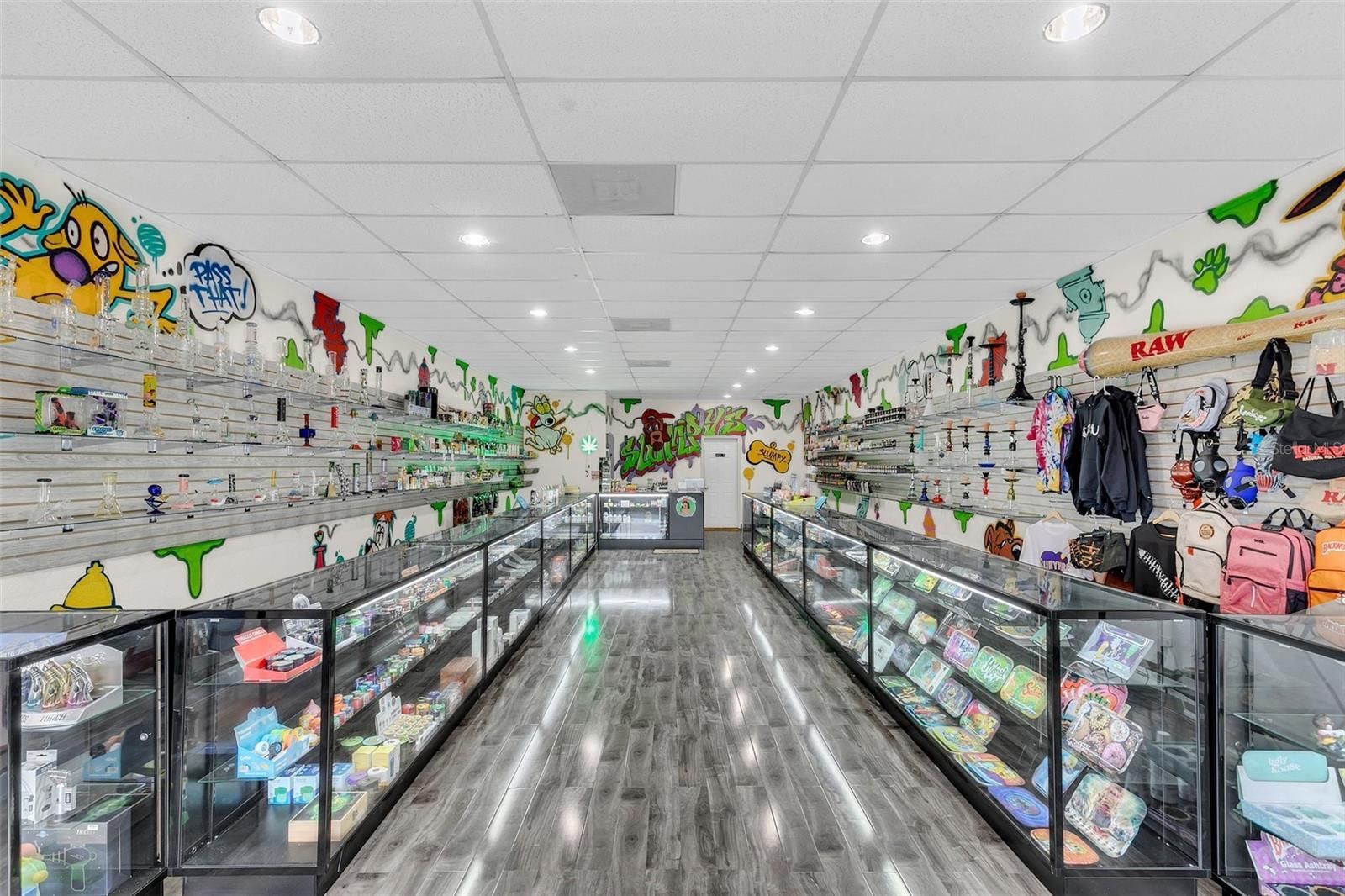 A very long aisle in a store filled with lots of glass display cases.