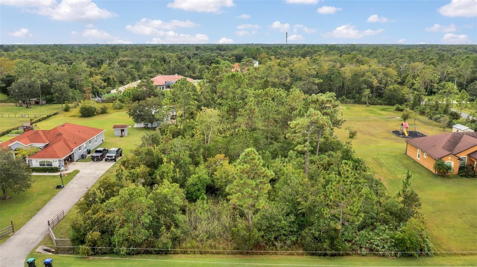 An aerial view of a house and a lot of trees.