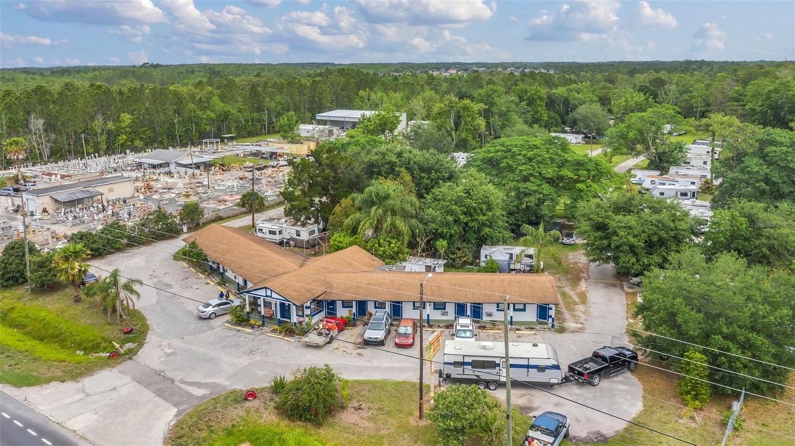 An aerial view of a motel with a lot of cars parked in front of it.