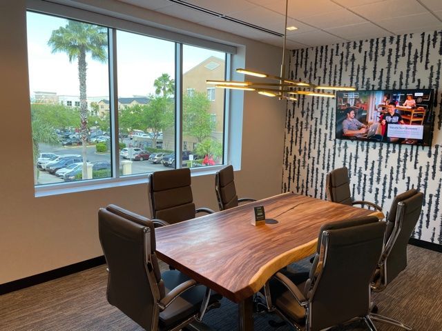A conference room with a large wooden table and chairs.