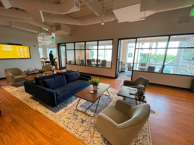 A living room with a couch , chairs , and a coffee table.