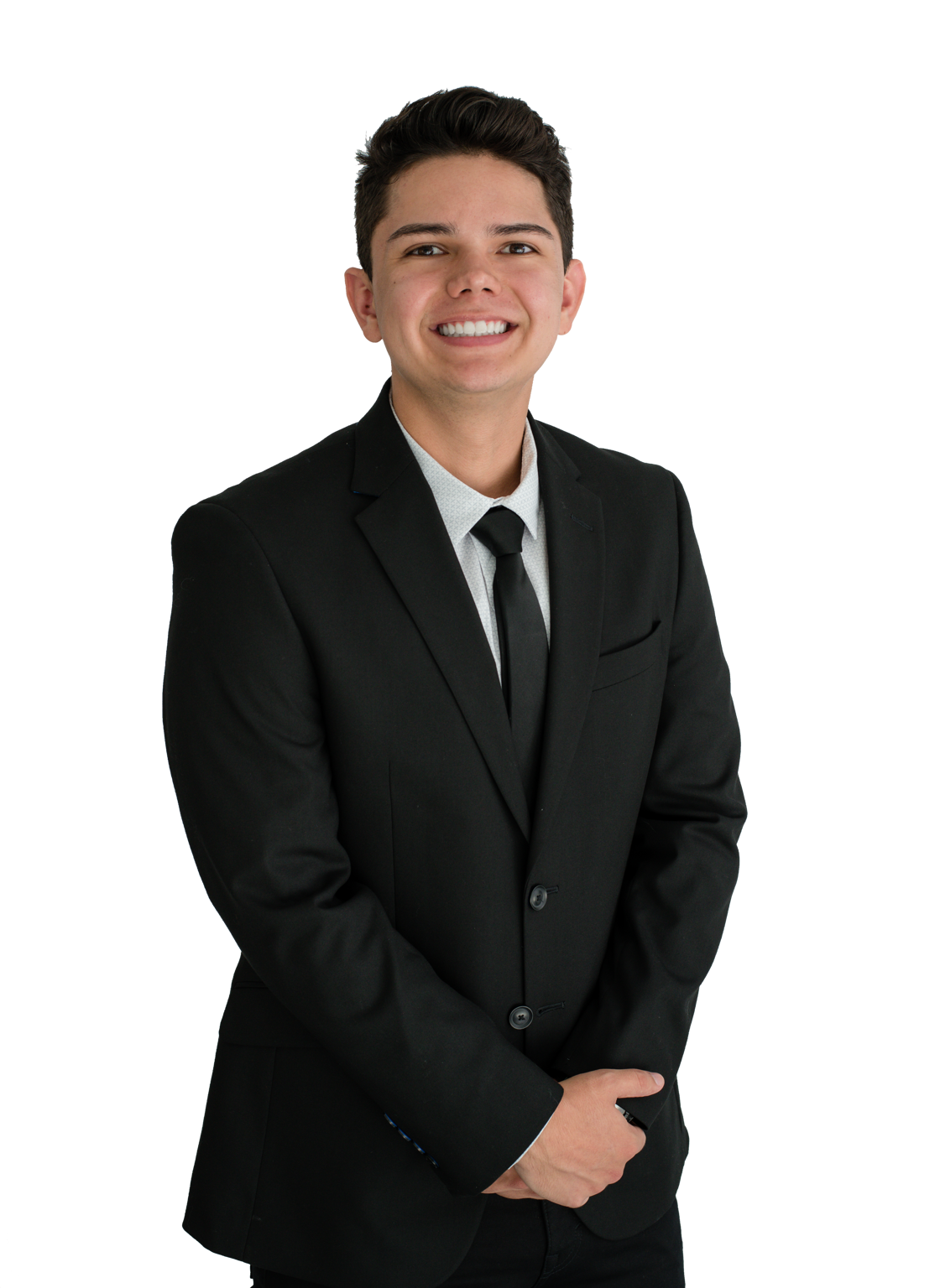 Young man in black suit and tie smiling, arms crossed in front of him.