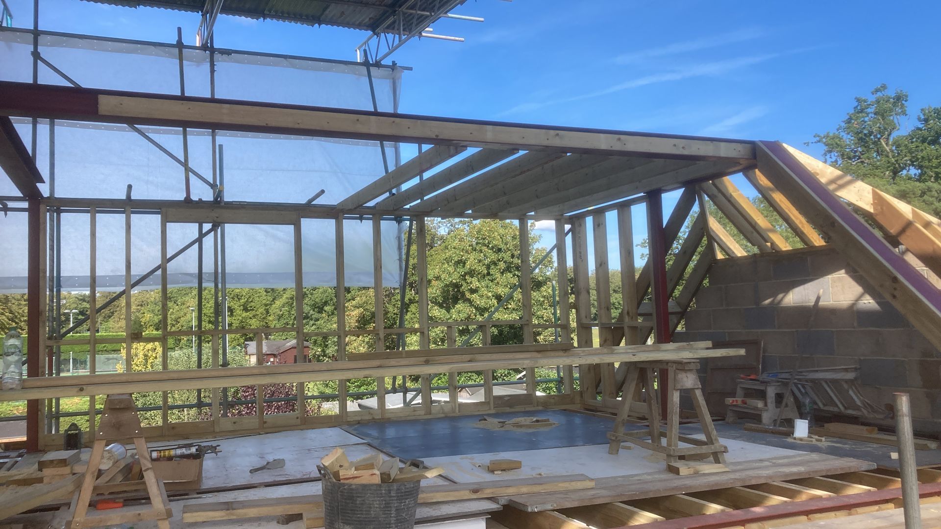A building under construction with scaffolding and a blue sky in the background.