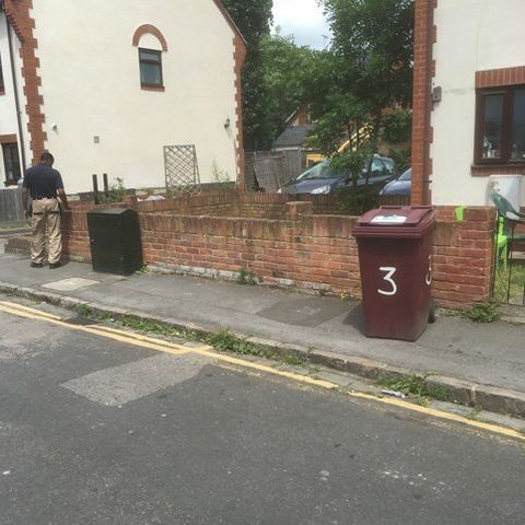dustbins on the side of a footpath