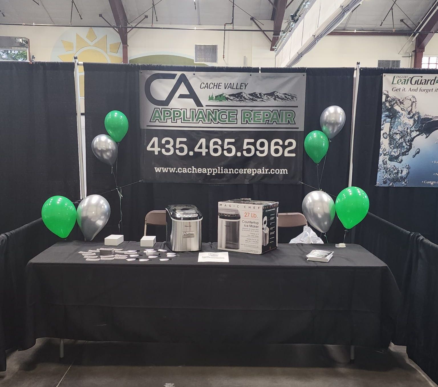 A table with balloons and a sign that says ca appliance repair