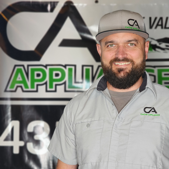 A man with a beard wearing a hat is standing in front of a sign that says appliance 43