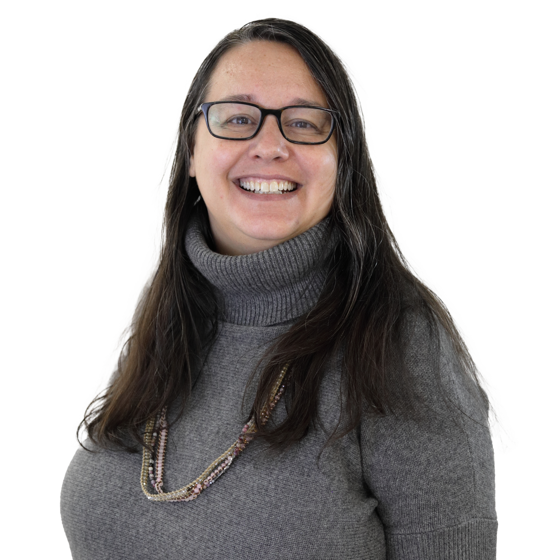 Woman with glasses smiles, wearing a gray turtleneck sweater and beaded necklace.