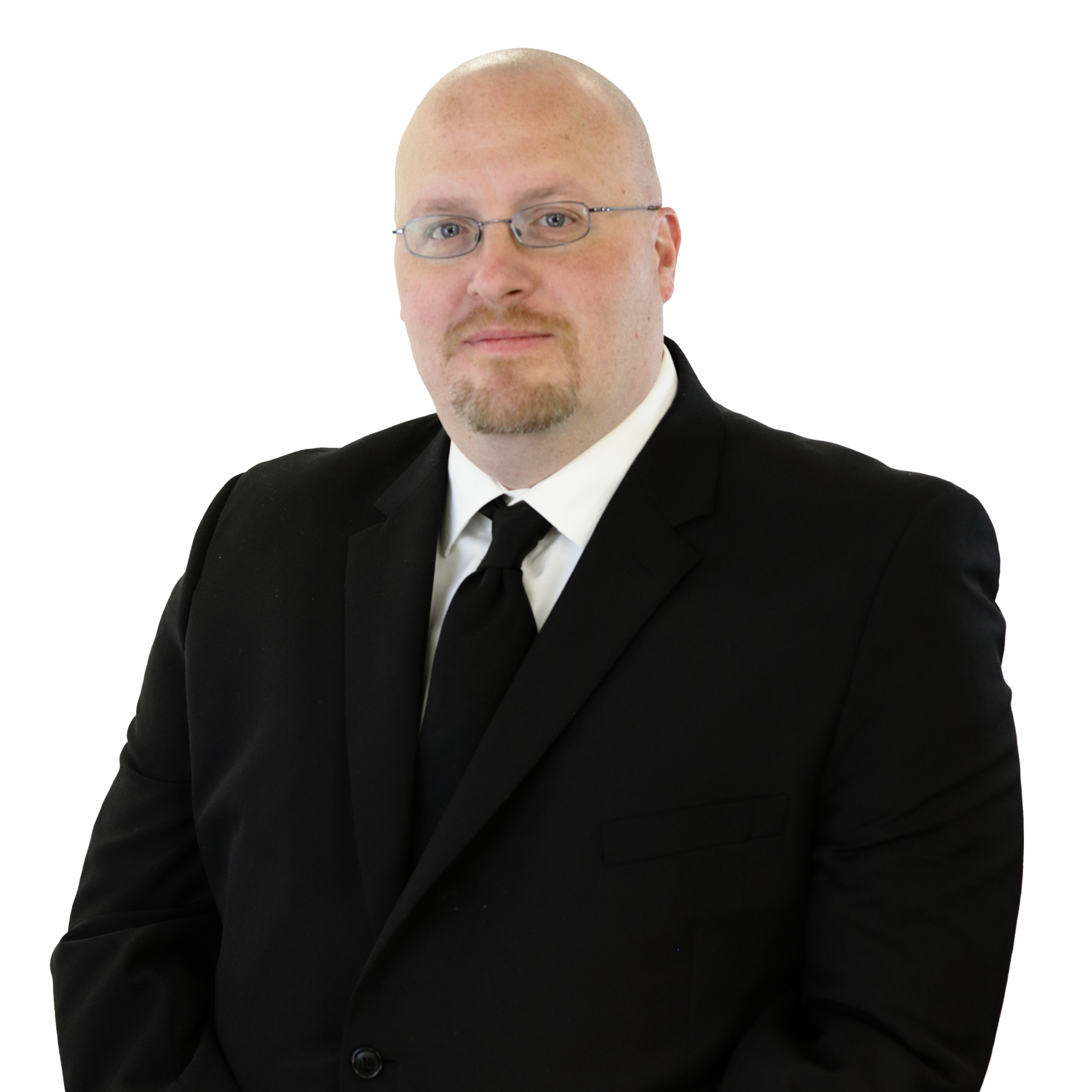 Bald man wearing glasses, black suit, and tie against a white background.