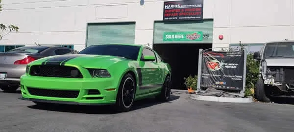 Bright green sports car parked outside a storefront beside two trash bins