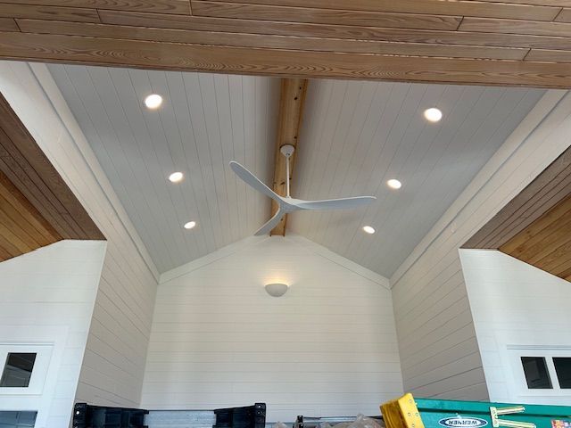 White-paneled ceiling with recessed lights, a ceiling fan, and wooden beams.