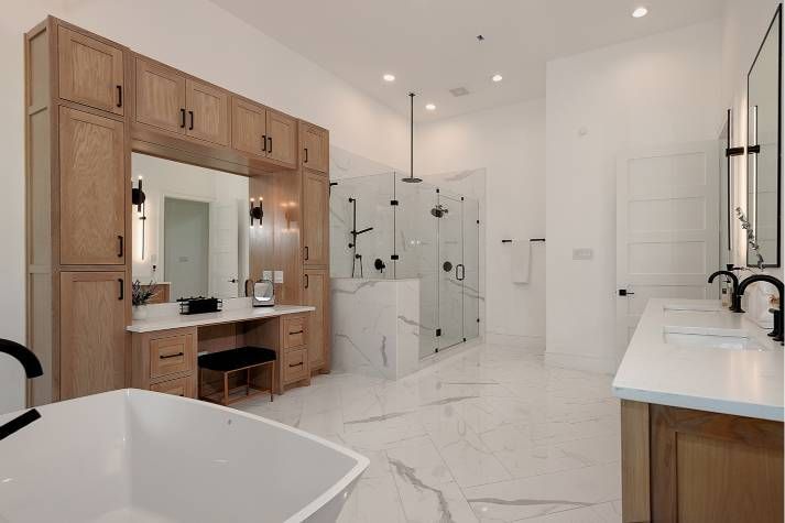 A bathroom with a bathtub , sinks , mirrors and a walk in shower.