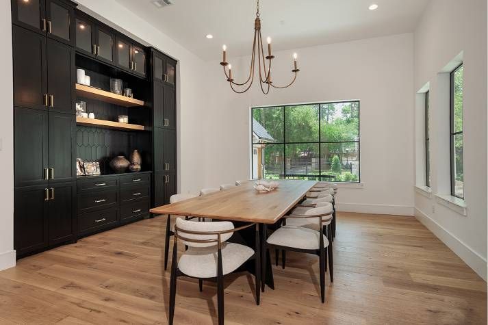 A dining room with a long wooden table and chairs and a chandelier.