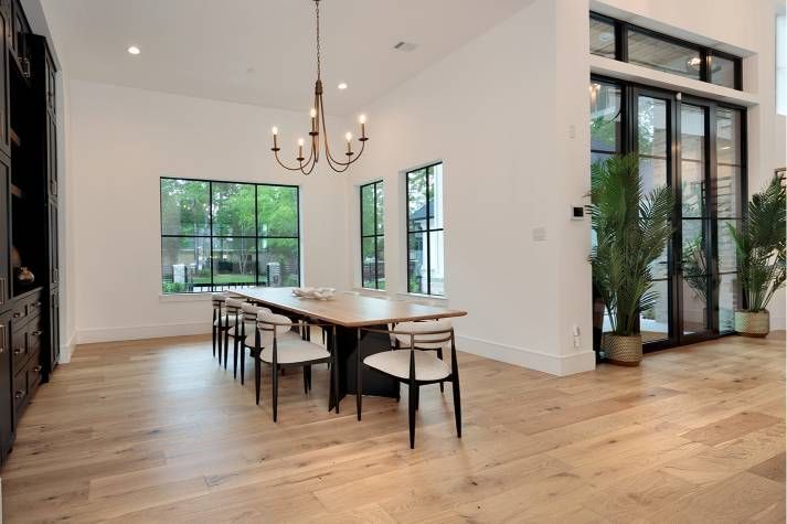 A dining room with a long table and chairs and a chandelier.