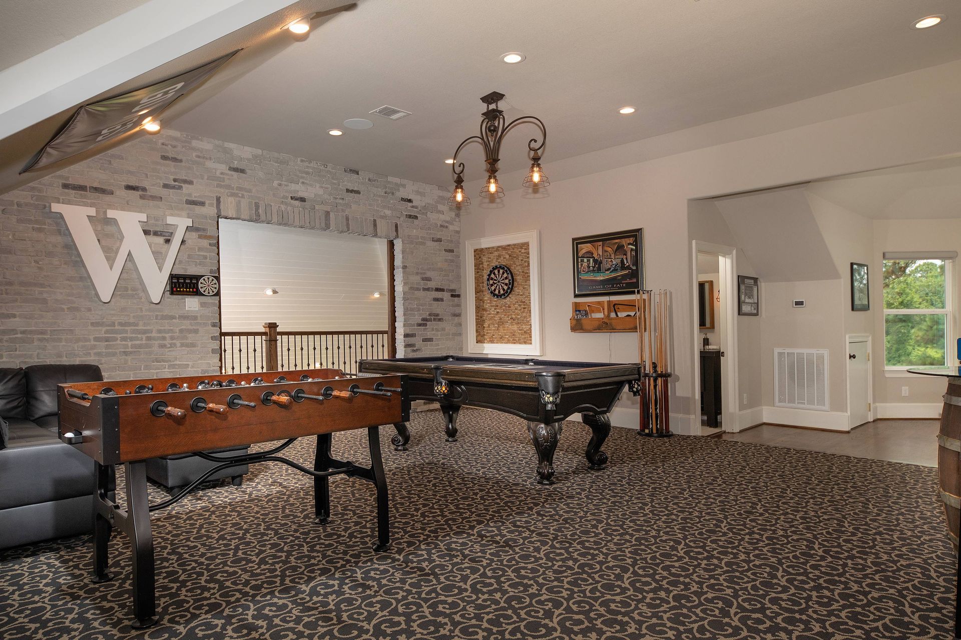 A game room with a pool table and a foosball table
