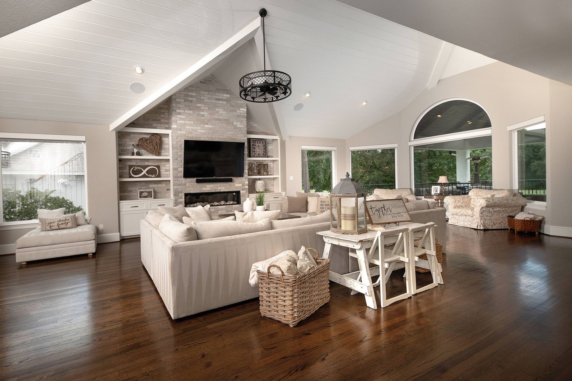 A living room with a large white couch and a flat screen tv