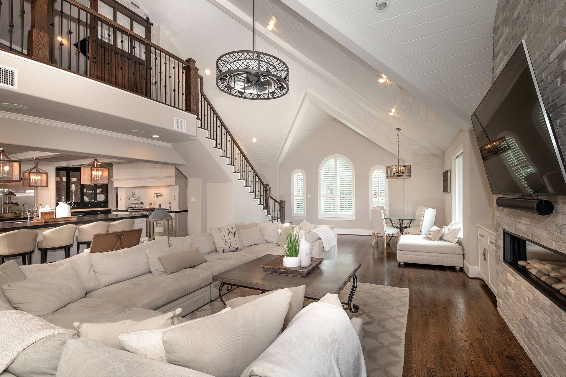 A living room with a large sectional couch and a flat screen tv