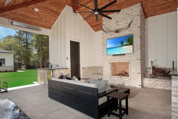 A living room with a fireplace and a ceiling fan.